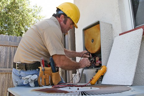 An air conditioning repairman working on a heat recovery unit.
